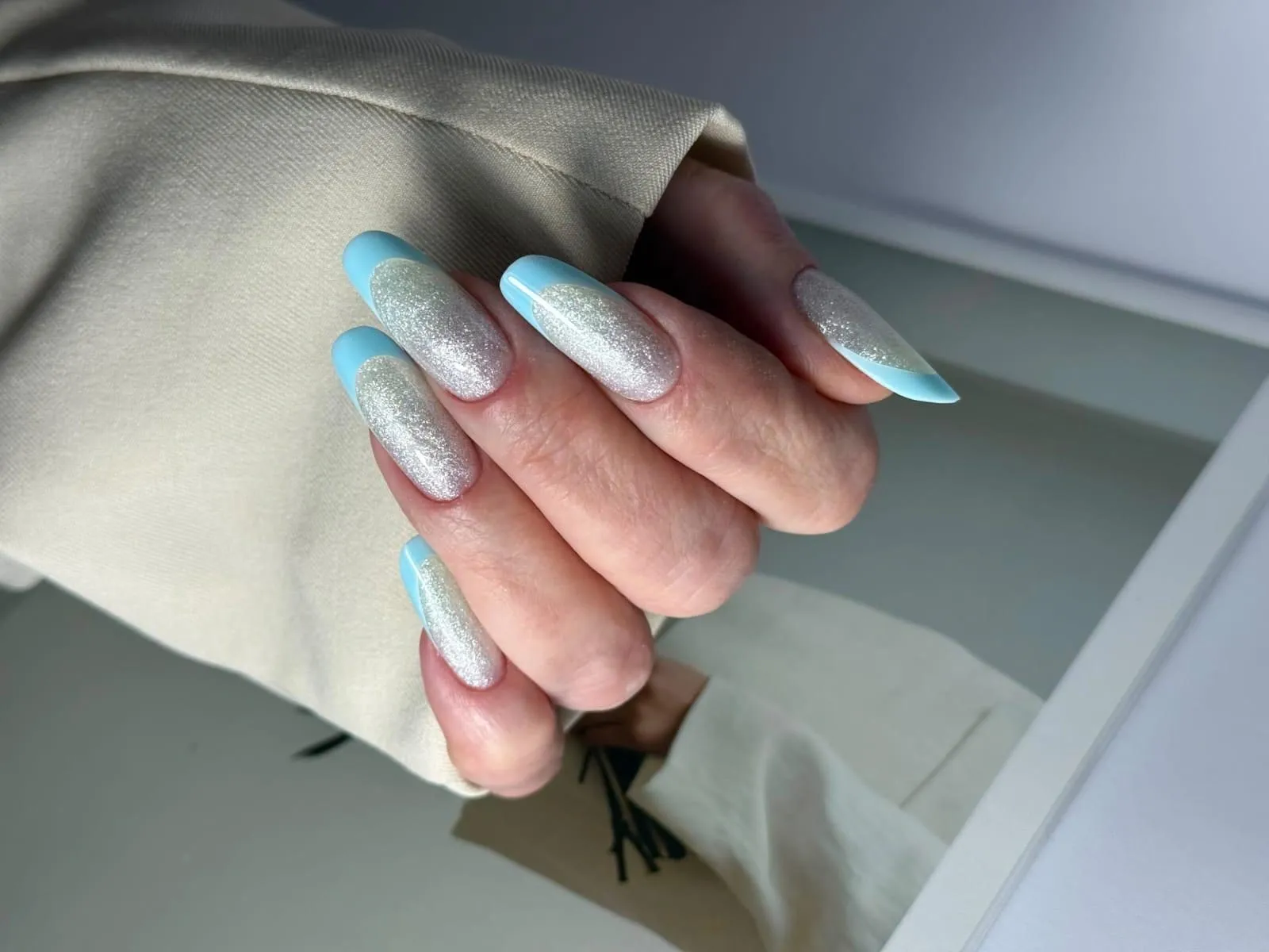 Manichiură cu sclipici argintiu și vârfuri french bleu, unghii lungi
